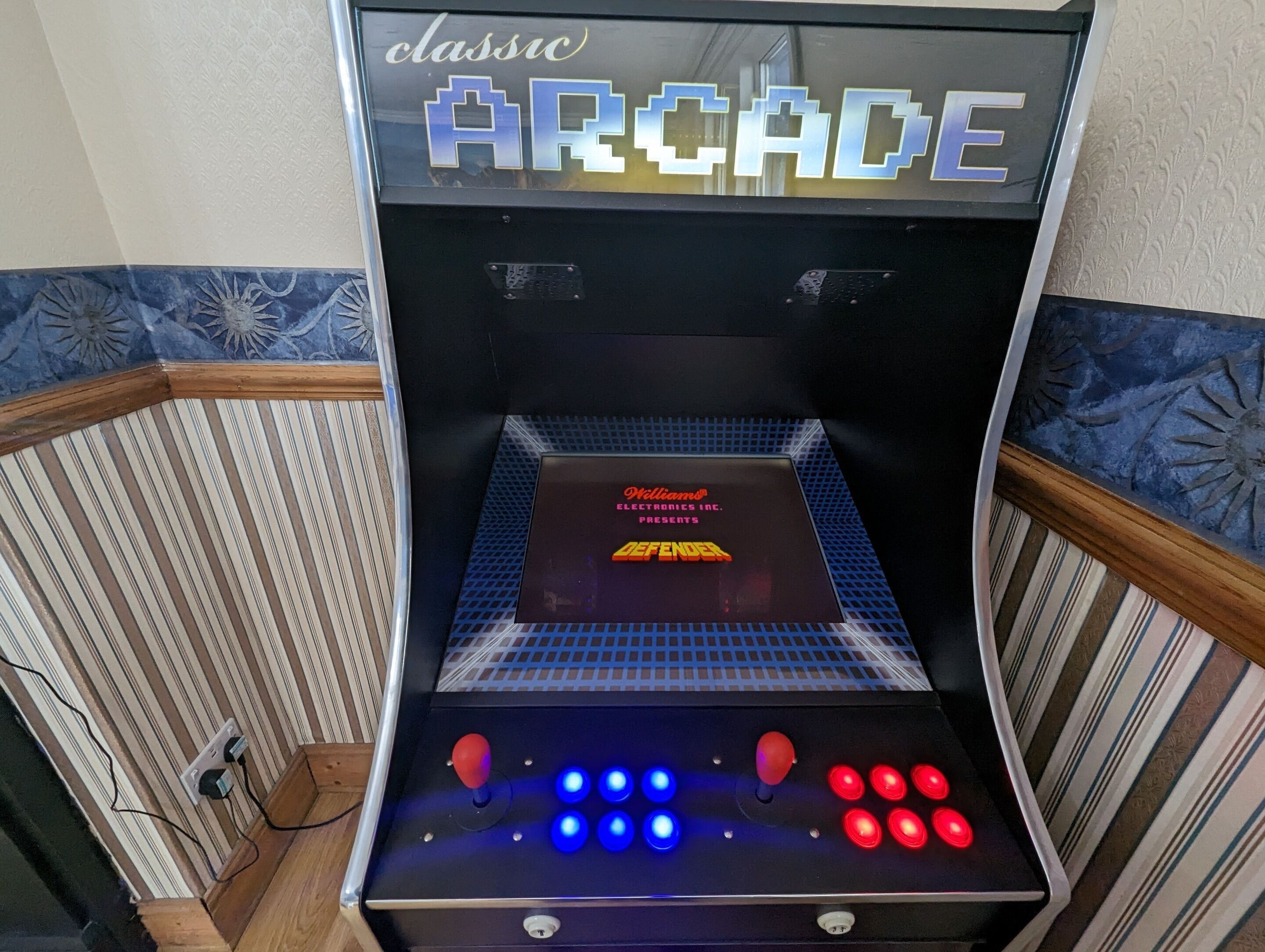Een klassieke speelautomaat met neonverlichting, een joystick en meerdere knoppen.