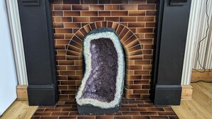 A fireplace with a brick surround and a decorative stone piece in the center. - Jurassic Bay Holidays (Weymouth)
