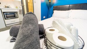 A hotel room with a bed, towels, and toiletries. - Beautiful 1-bed Studio in Birmingham (Birmingham)