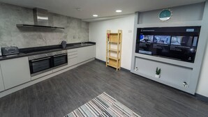 A modern kitchen with a built-in oven, a coffee maker, and a wooden ladder shelf. - Beautiful 1-bed Studio in Birmingham (Birmingham)