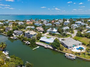 Un quartier résidentiel situé sur la côte, avec des maisons, un port de plaisance et une vue dégagée sur l’océan.
