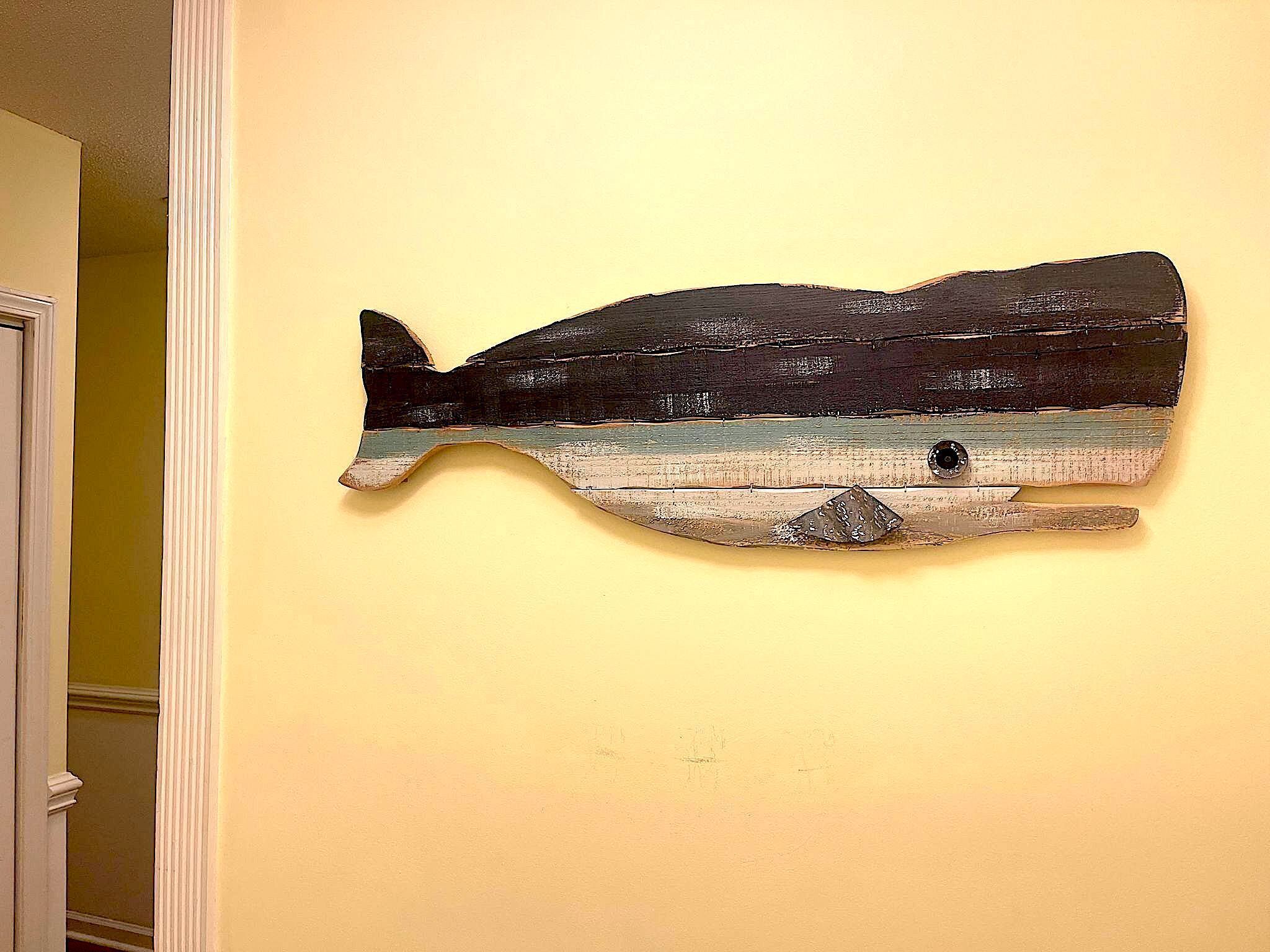 Une œuvre d’art représentant une baleine, fixée au mur.