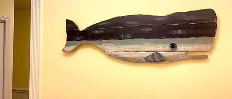 Une œuvre d’art représentant une baleine, fixée au mur.