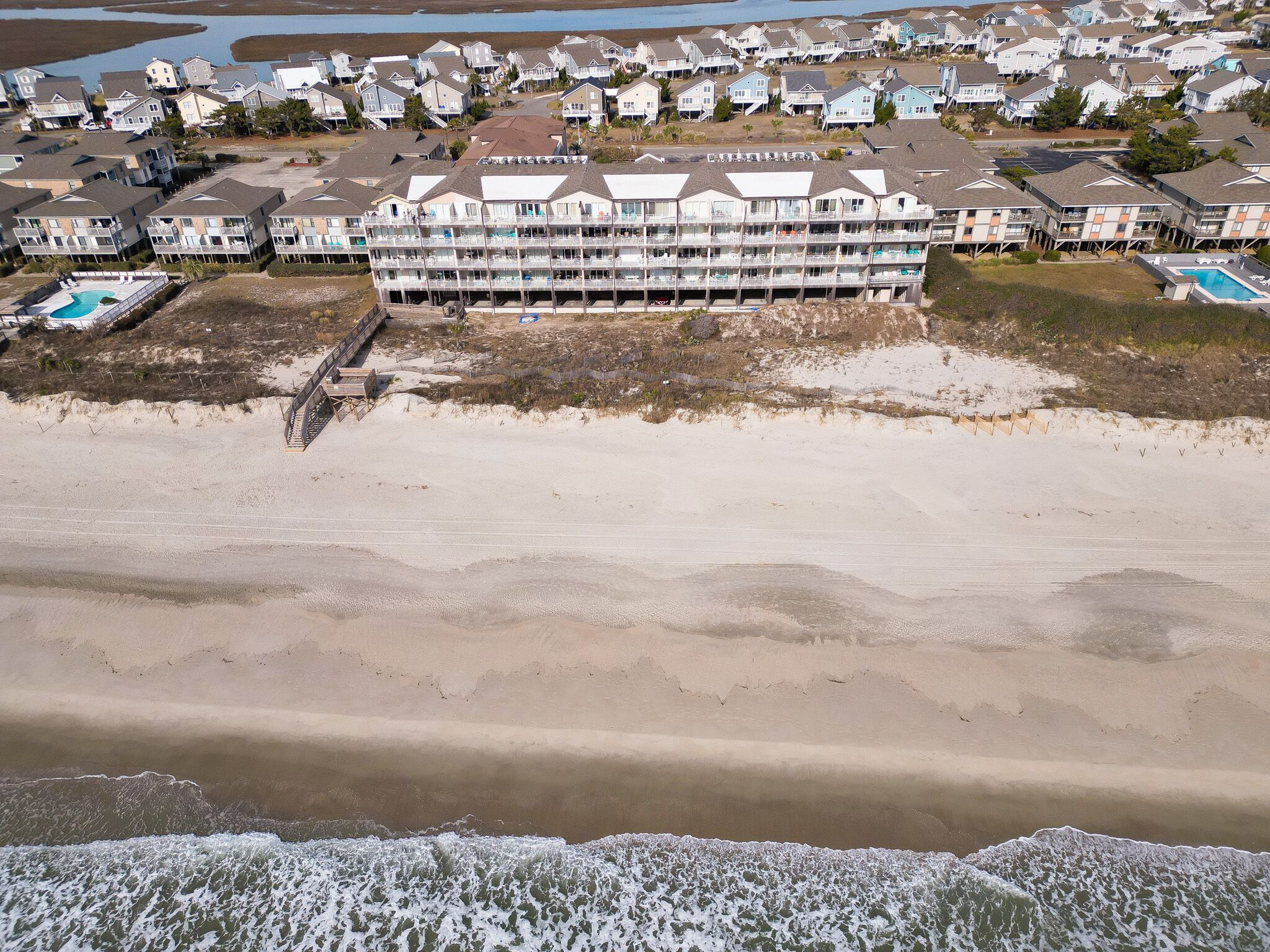 Un hôtel situé en bord de mer, doté de nombreux balcons, d’une piscine et d’un accès direct à la plage.