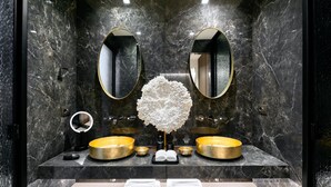 A modern bathroom with two gold sinks, a large mirror, and a decorative white structure. - Remarkable 7-bed Villa in Mikonos - Villa Ataraxia (Mykonos)