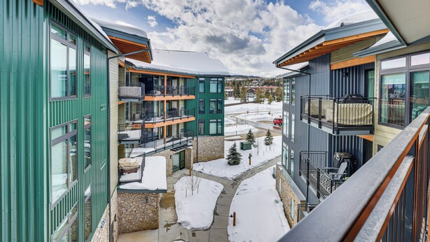 A modern building with multiple balconies, large windows, and a view of a snowy landscape. - Downtown Winter Park Condo ~ 3 Mi to Skiing! (Winter Park)