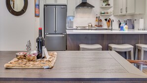 A modern kitchen with a central island, stainless steel appliances, and bar stools. - Downtown Winter Park Condo ~ 3 Mi to Skiing! (Winter Park)