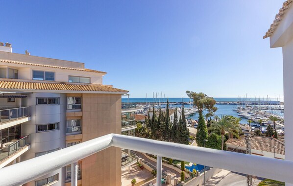 Un balcon avec vue sur un port de plaisance et la mer.