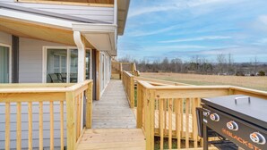 A wooden deck leading to a house with a grill area. - 'deer Lake Lodge' on 700 Wooded Acres in Dayton! (Dayton)