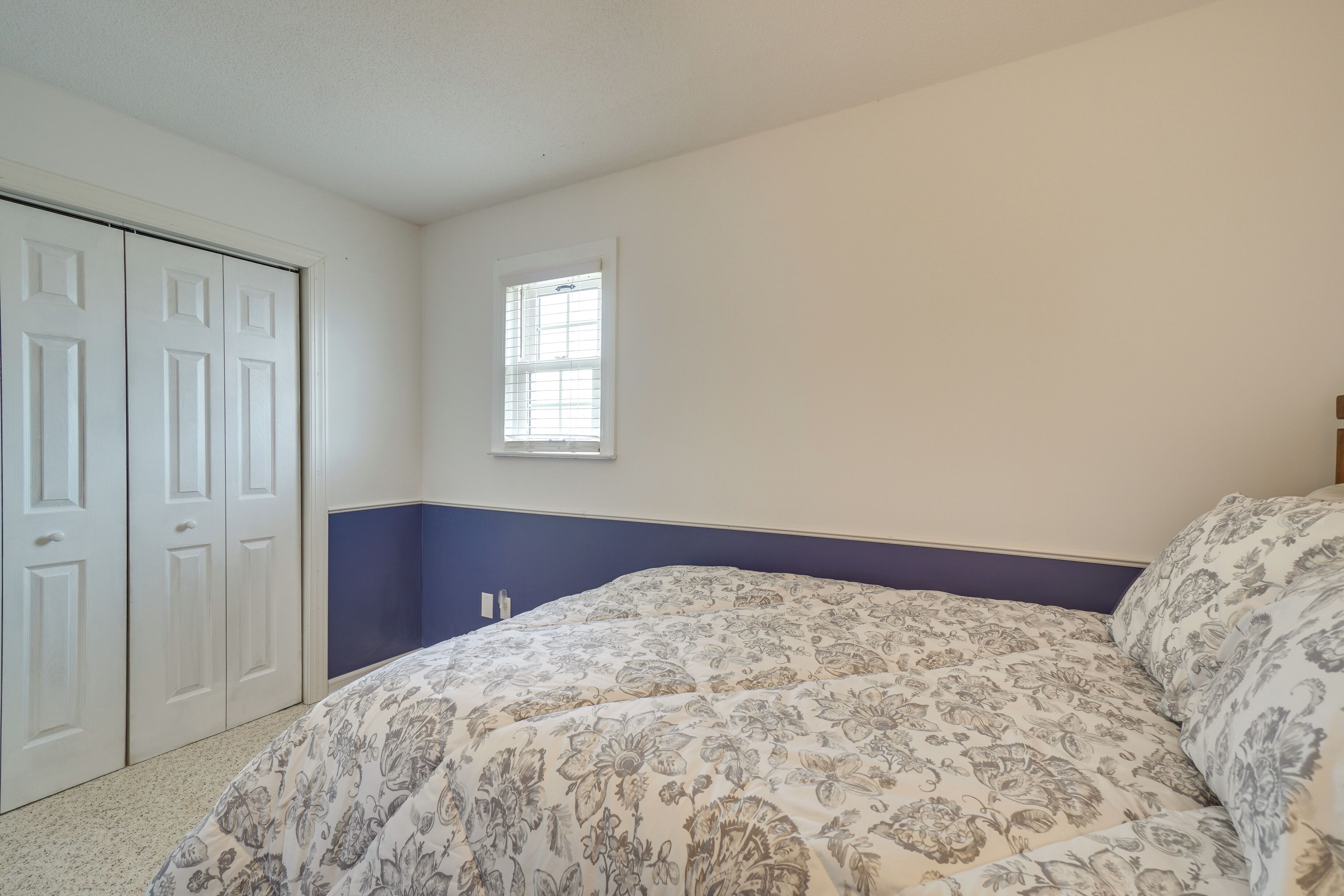 Une chambre à coucher avec un lit, une fenêtre et une porte.