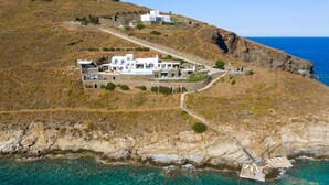 A coastal property with multiple white buildings, a clear view of the sea, and a rocky landscape. - Inviting 8-bed Villa in Ermoupoli - Villa Blueros (Syros)