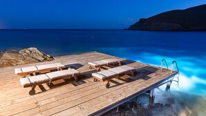 A wooden deck with lounge chairs and a ladder leading into clear blue water. - Inviting 8-bed Villa in Ermoupoli - Villa Blueros (Syros)