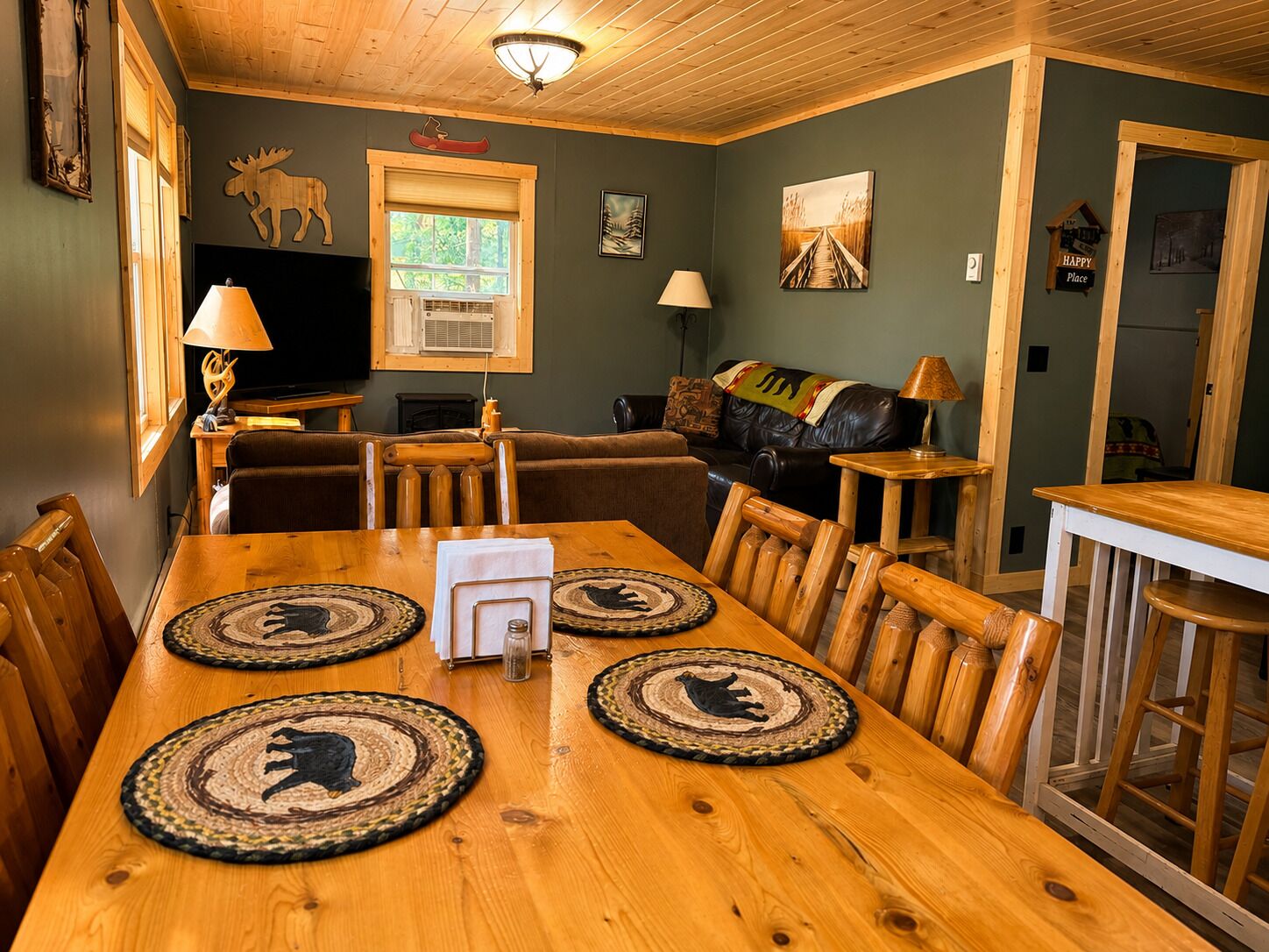A dining area with a wooden table, chairs, and placemats with animal designs.