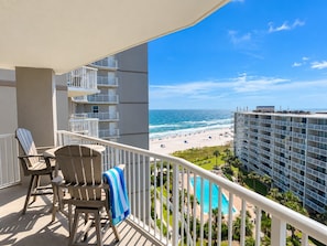 A balcony with two chairs and a pool view. - Tradewinds 908 | Heated Swim-Through Pool | Gulf Views | Orange Beach (Orange Beach)