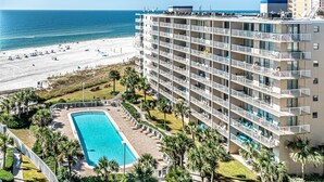 Un hôtel de grande hauteur doté de nombreux balcons, d’une piscine et offrant une vue sur la plage.