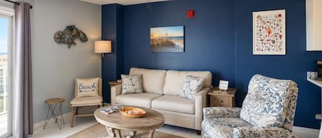 Un salon comprenant un canapé, un fauteuil, une table basse et un ventilateur de plafond.