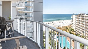 Un balcon avec vue sur une plage et une piscine.