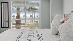 A bedroom with a bed, white bedding, and a window with blinds. - Ocean & Pool Views, W/D in Condo, 2 King Beds (Galveston)
