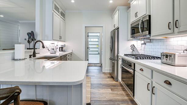 A modern kitchen with white cabinetry, stainless steel appliances, and a central island. - Idyllic Murrells Inlet Home < 1 Mi to Marsh Walk (Murrells Inlet)