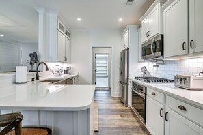 A modern kitchen with white cabinetry, stainless steel appliances, and a central island. - Idyllic Murrells Inlet Home < 1 Mi to Marsh Walk (Murrells Inlet)
