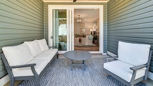 A covered patio area with a gray sofa, a round table, and a chair. - Idyllic Murrells Inlet Home < 1 Mi to Marsh Walk (Murrells Inlet)