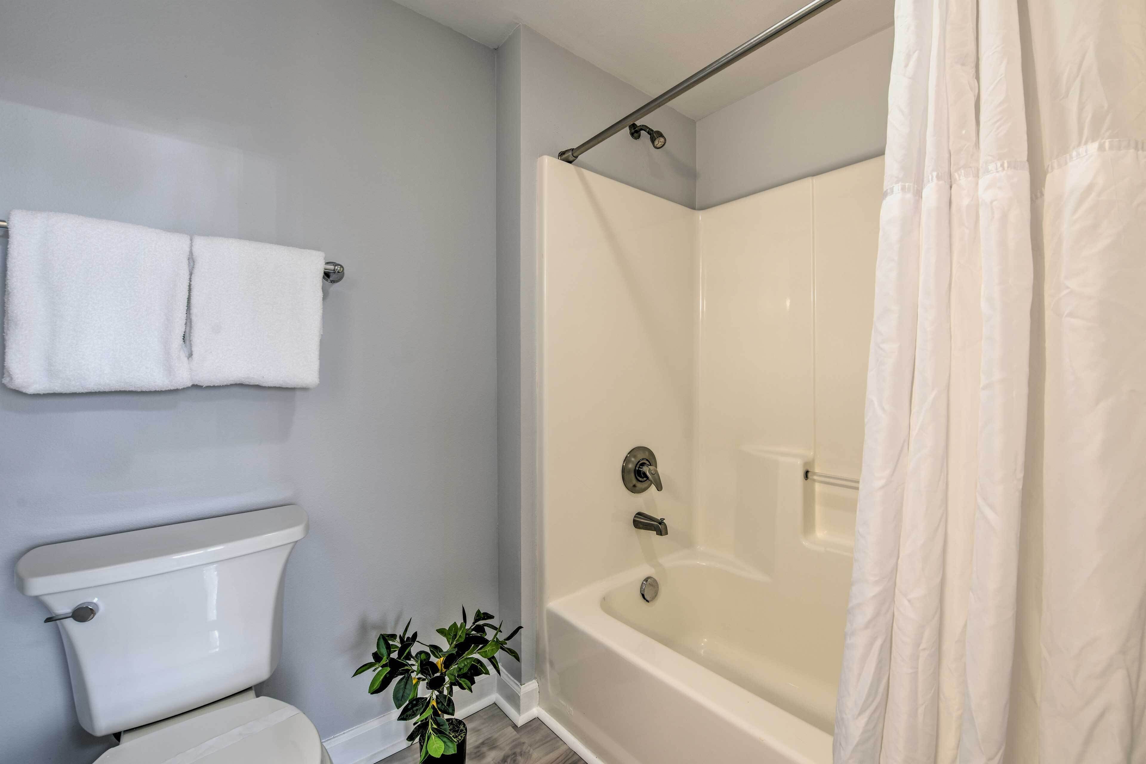 A bathroom with a toilet, a bathtub, and a shower curtain.