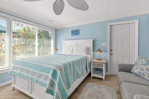 A bedroom with a bed, bedside table, nightstand, and a door. - Las Hermanas 4 1 Bedroom Studio by RedAwning (Longboat Key)