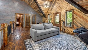 Un loft spacieux avec de hauts plafonds, des poutres apparentes et une grande fenêtre qui laisse entrer la lumière naturelle.