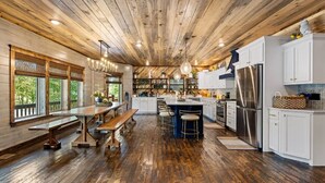 Une cuisine spacieuse dotée d’un plancher en bois, de meubles blancs et d’un îlot central.