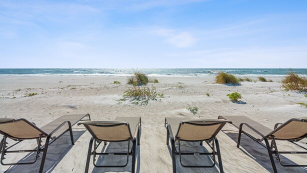 A beach view with four lounge chairs facing the ocean. - Las Hermanas 1 Studio by RedAwning (Longboat Key)