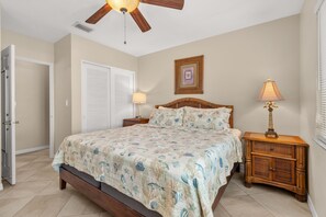 A bedroom with a bed, a nightstand, a ceiling fan, and a door. - Las Hermanas 3 1 Bedroom Condo by RedAwning (Longboat Key)