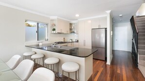 A modern kitchen with a central island, bar stools, and a stainless steel refrigerator. - Panoramic views, 5-bedroom waterfront (Sylvania)