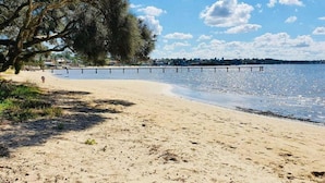 A beach with a sandy shore, a pier extending into the water, and a tree line on the left. - Panoramic views, 5-bedroom waterfront (Sylvania)