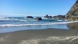 Una playa con formaciones rocosas y olas tranquilas.