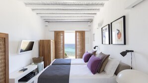 A modern bedroom with a large bed, a desk, and a view of the sea. - Stunning 5-bed - Villa Big Blue (Mykonos)