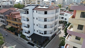 A multi-story building with balconies, a flat roof, and a street view. - MondurO Hotel (Durrës)