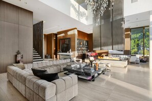 Un salon moderne avec un canapé d’angle, une cheminée et un coin bar.