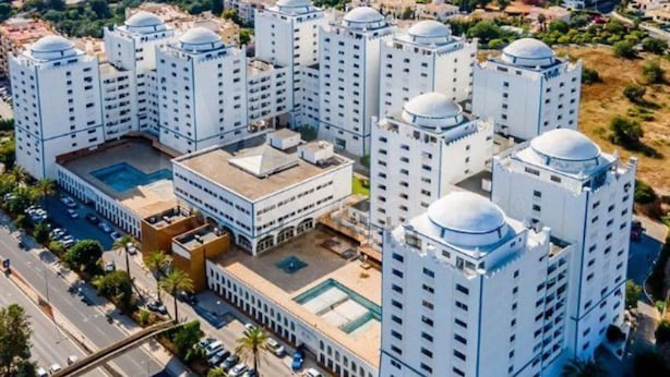 A high-rise residential building with multiple floors, a central courtyard, and a swimming pool. - 1-bed - Sleeps 4 - Free Parking (Portimão)