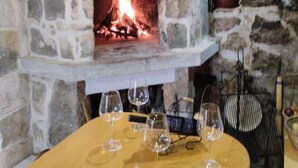 Une cheminée en pierre avec un feu qui crépite à l’intérieur, entourée de murs en pierre.