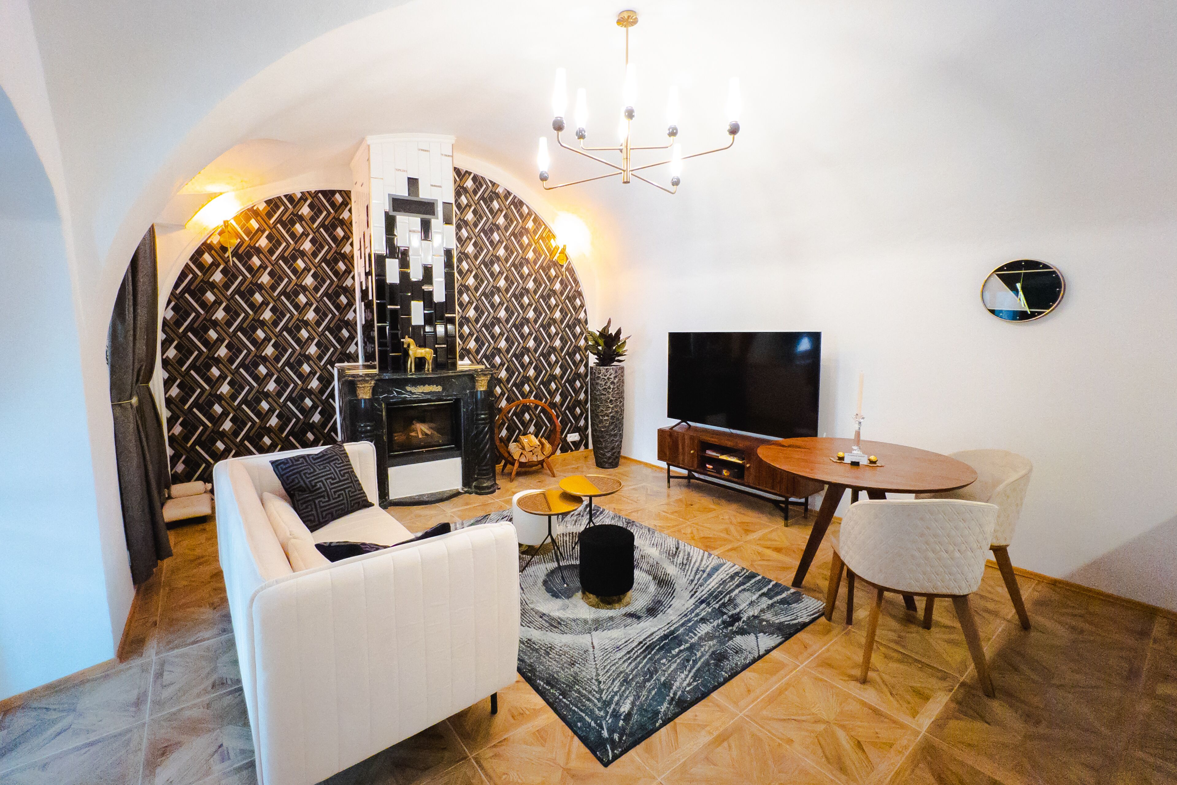 Una sala de estar moderna con un sofá, una mesa de centro, televisor y chimenea.