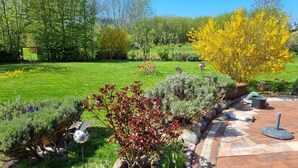 A garden with various plants, a paved pathway, and a metal sculpture. - Beautiful vacation apartment (1) on the north beach with WiFi for up to 4 people from 9 € pP (Putgarten)