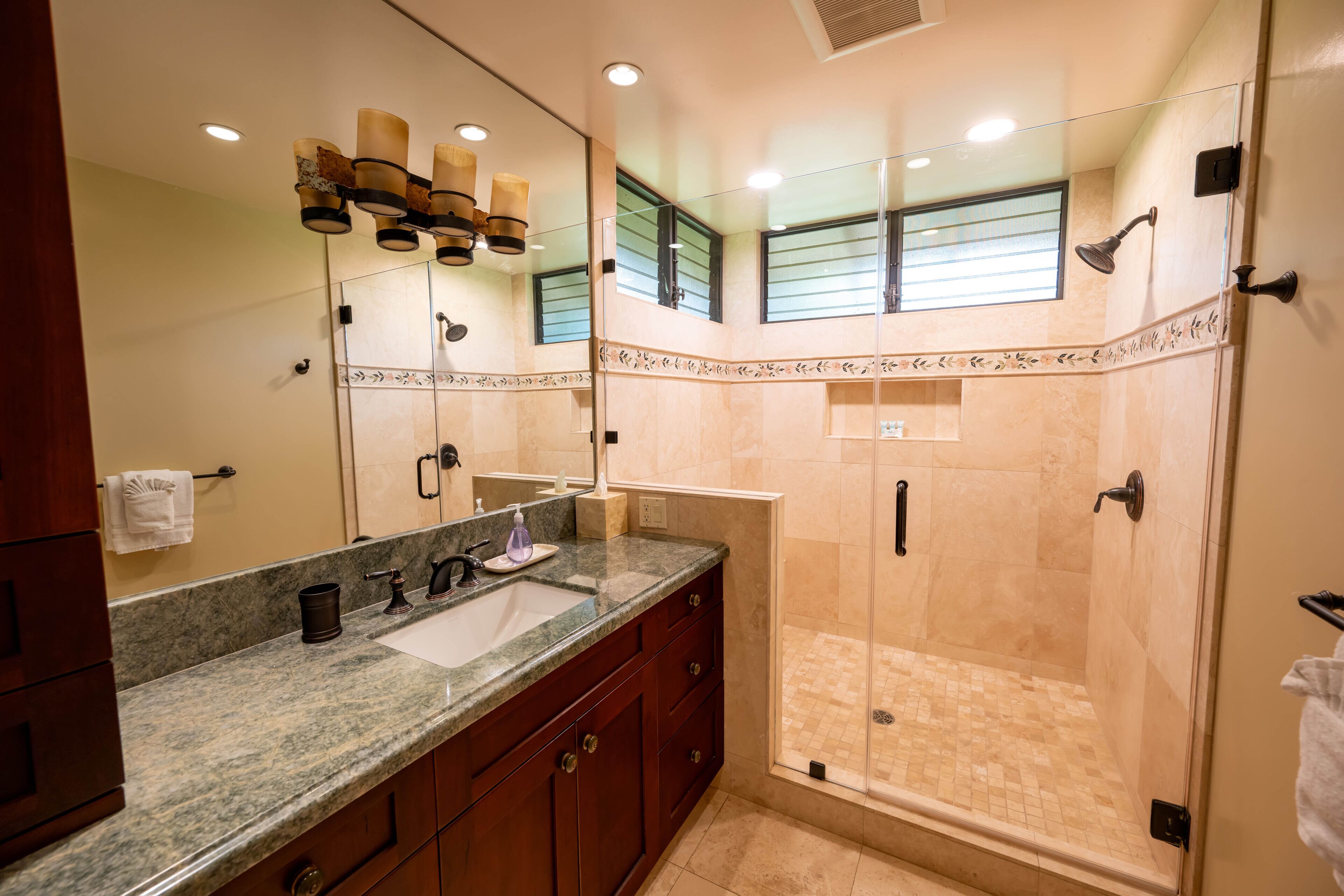 Un baño con un espejo grande, un lavabo y una zona de ducha.
