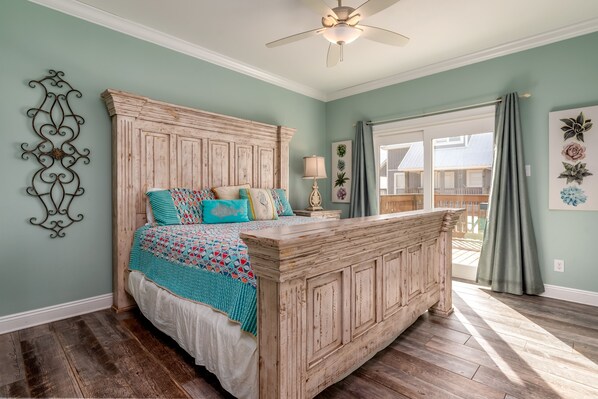 A bedroom with a large bed, wooden headboard, and a view to the outside.