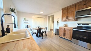 A kitchen with wooden cabinets, a stainless steel oven, and a sink.