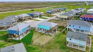A coastal residential area with multiple two-story houses featuring balconies and waterfront access. - AfterDuneDelight-Fenced in yard-3 bedroom, 2 bath, sleeps 10 (Crystal Beach)