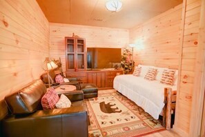 A cozy wooden cabin room with a bed, a desk, a chair, and a couch. - Eagles Landing - Blue Ridge GA (Blue Ridge)