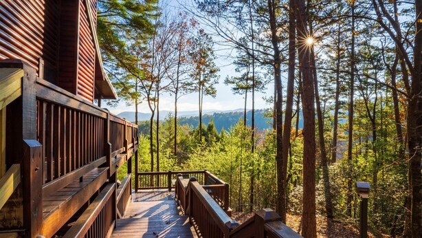 A wooden deck leading to a cabin with a view of a forest and mountains. - Hog Heaven - Cherry Log GA (Cherry Log)
