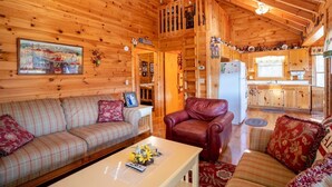 A cozy cabin interior with a living room, a dining area, and a kitchen. - Hog Heaven - Cherry Log GA (Cherry Log)
