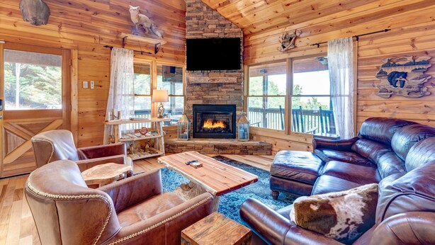 A cozy cabin interior with a stone fireplace, leather furniture, and rustic decor. - Sky Ridge - Blue Ridge GA (Blue Ridge)