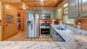 A kitchen with wooden cabinets, stainless steel appliances, and a granite countertop. - Sky Ridge - Blue Ridge GA (Blue Ridge)